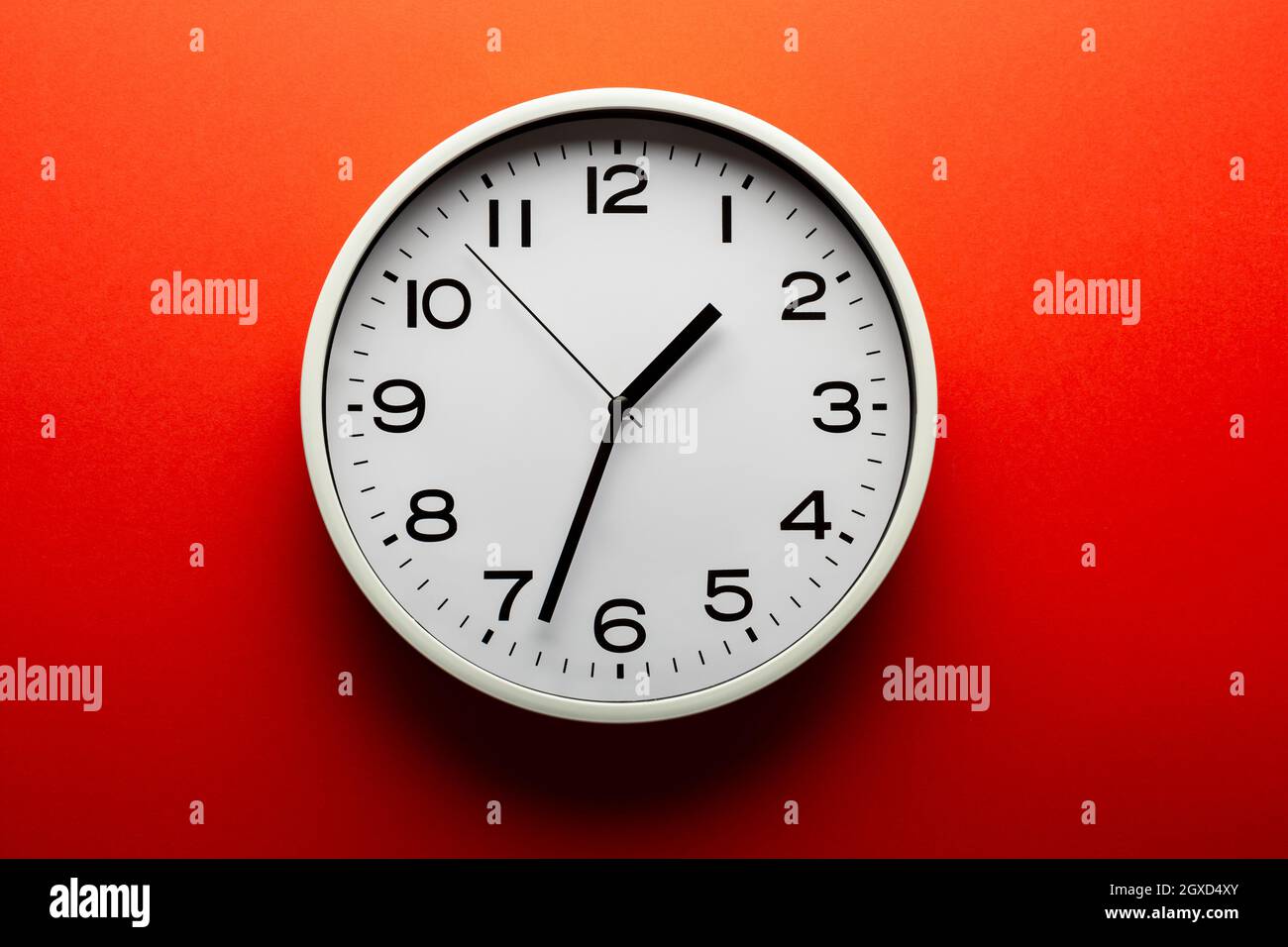 Round shaped minimalistic clock with numbers and arrows on colorful red ...