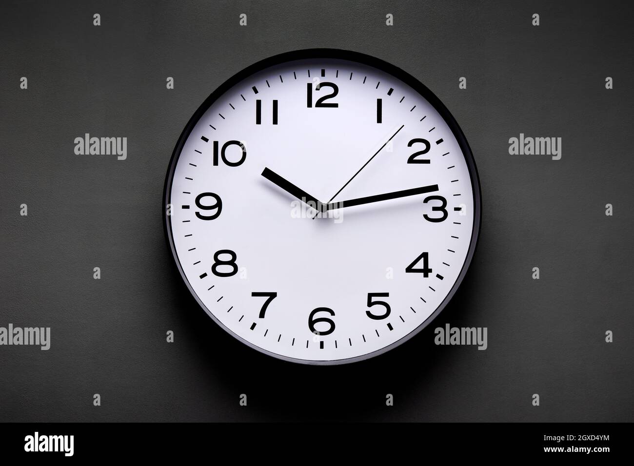 Round shaped minimalistic clock with numbers and arrows on black ...