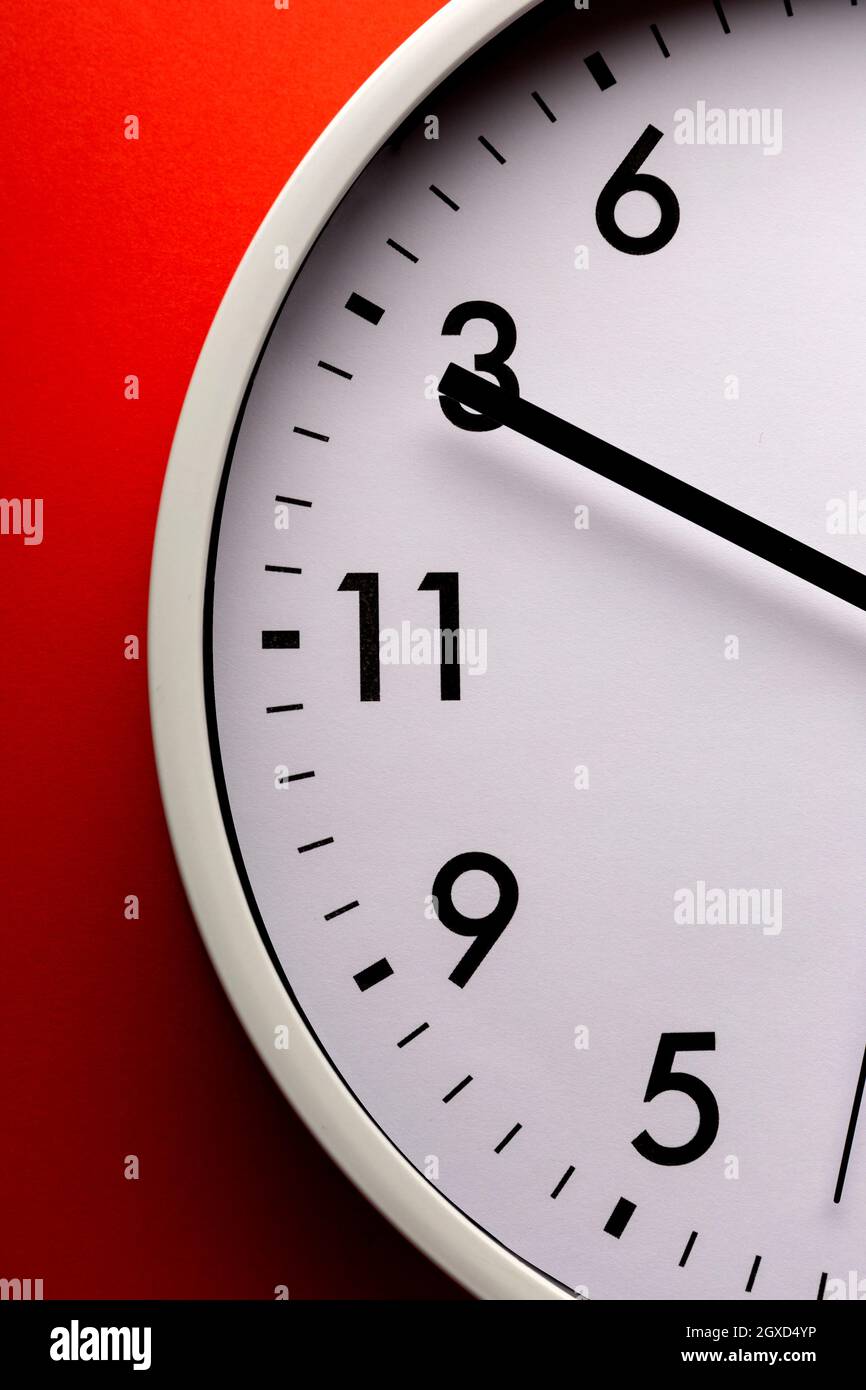 Round shaped minimalistic clock with numbers and arrows on colorful red ...