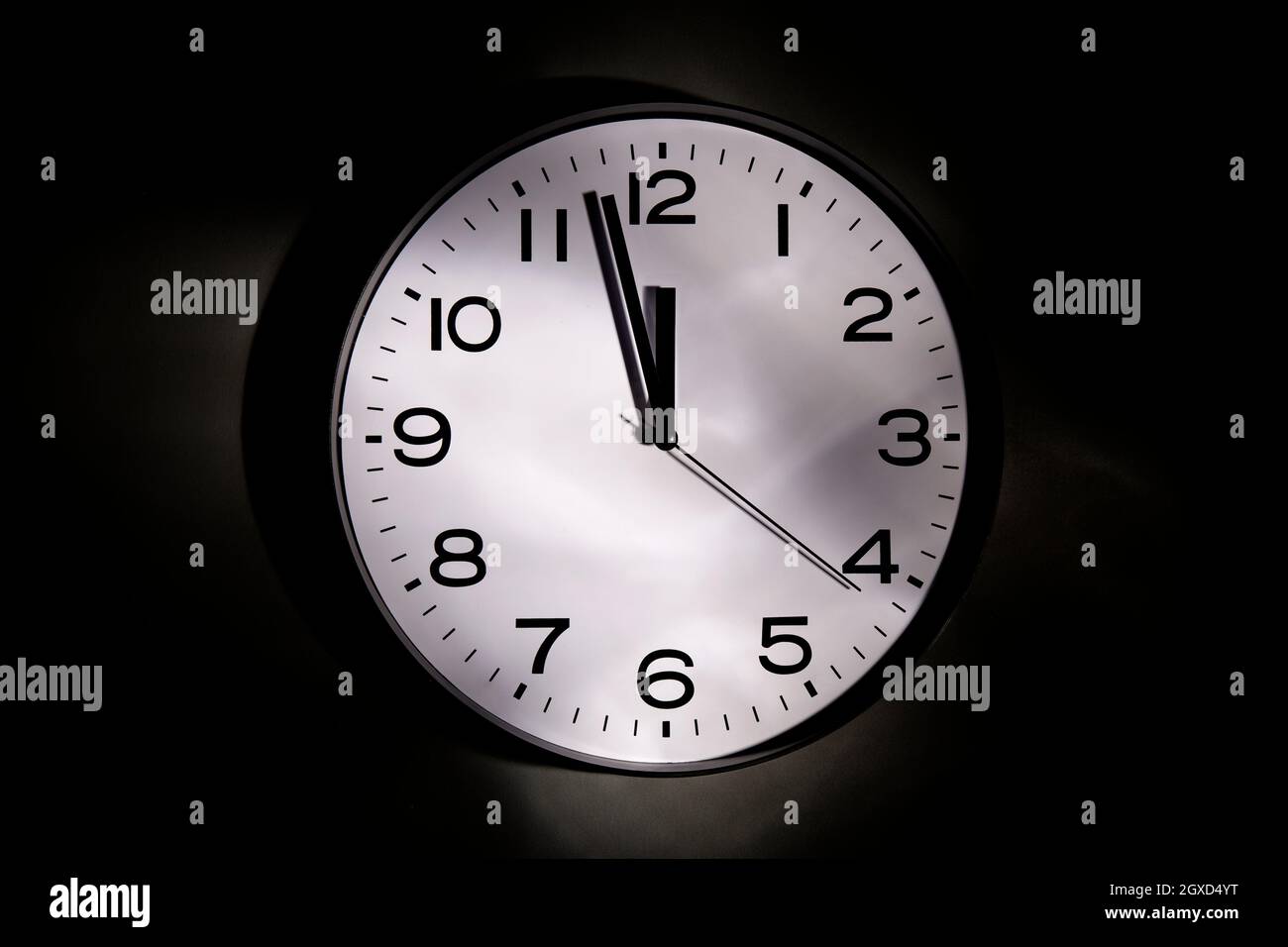 Round shaped minimalistic clock with numbers and arrows on black ...