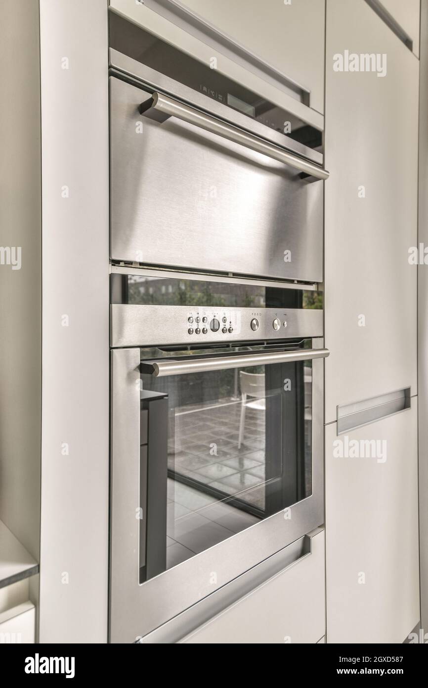Built in microwave and oven with control panel against fridge in