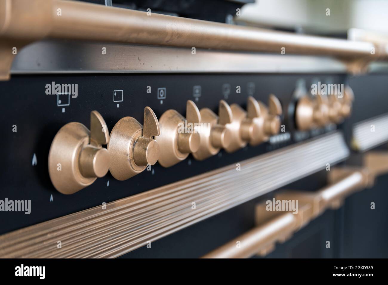Bronze stainless steel control knobs on front panel of modern stove in