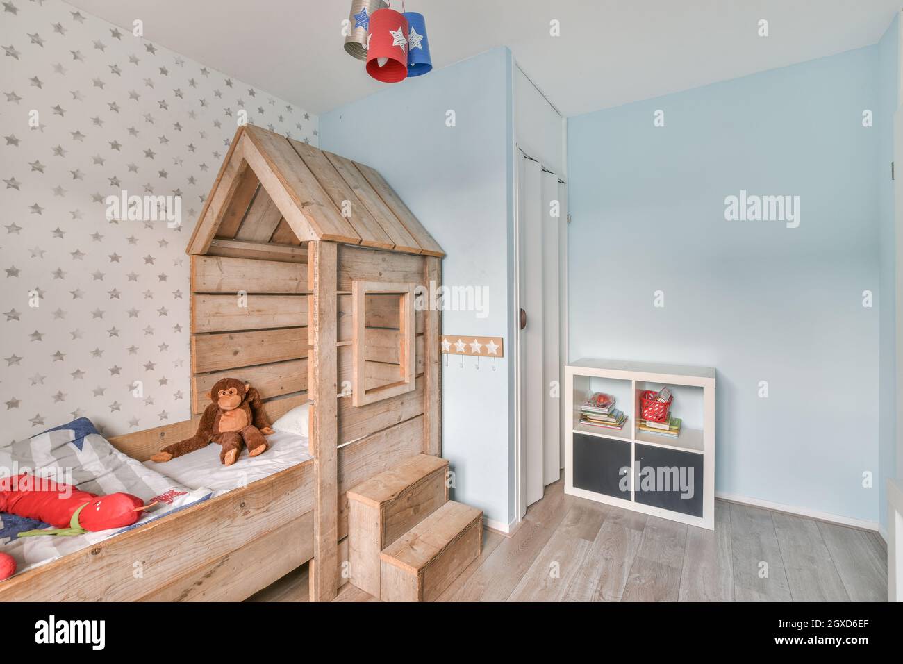 Contemporary interior of cozy nursery with creative wooden bed and soft
