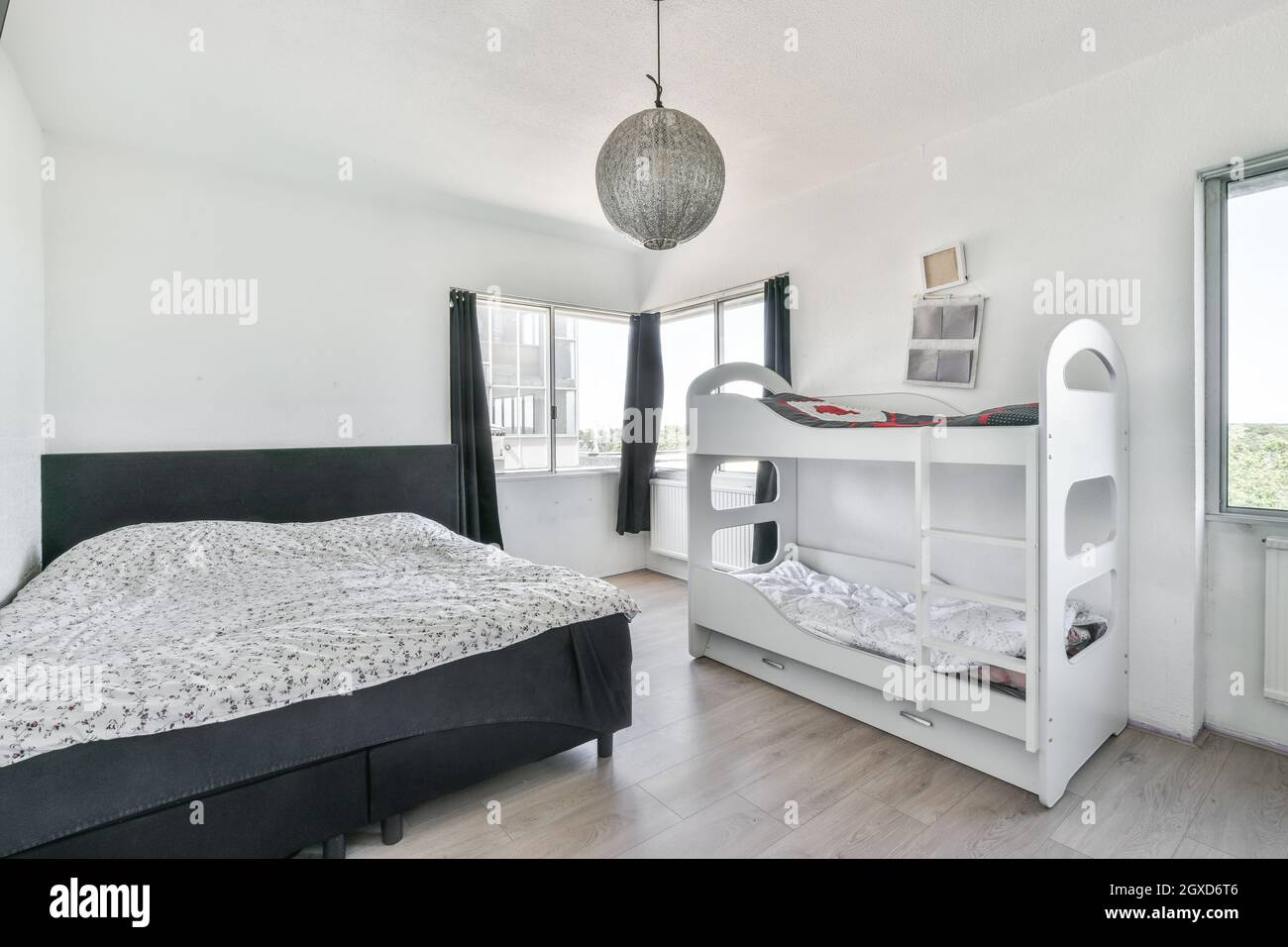 Modern interior of bedroom with black bed and white bunk bed in minimal