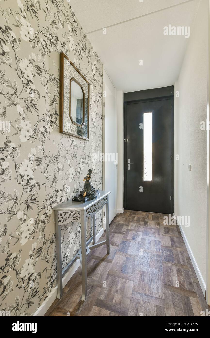 Interior of narrow hallway with floral ornament on wallpapers with
