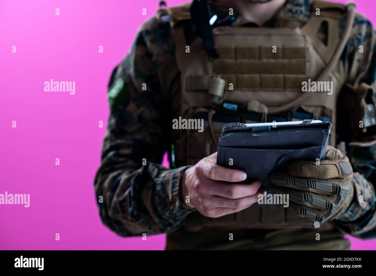 soldier using tablet computer hands closeup pnk background Stock Photo
