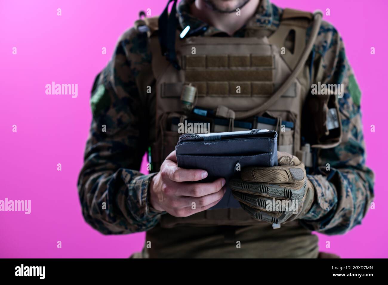 soldier using tablet computer hands closeup pnk background Stock Photo