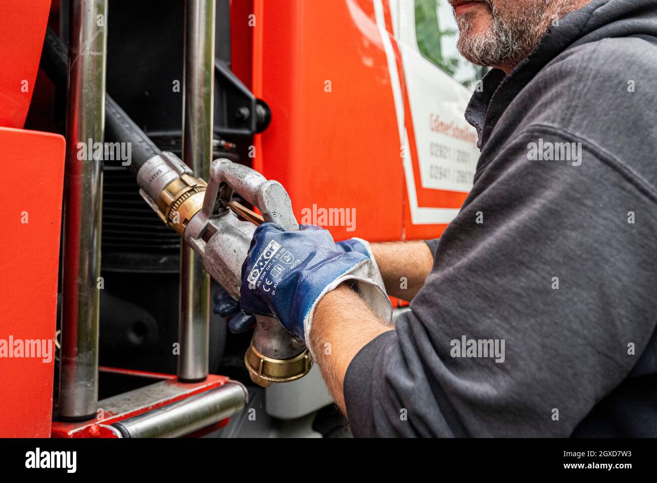 Lippstadt, Germany. 05th Oct, 2021. An employee pulls the hose for the heating oil delivery to a customer out of the tanker. Consumers can expect heating costs to rise sharply this year due to the high global demand for crude oil. It will be even more expensive in 2021 in homes with oil heating, where costs are expected to rise by 44 percent - after falling by 27 percent in the previous year. Credit: David Inderlied/dpa/Alamy Live News Stock Photo