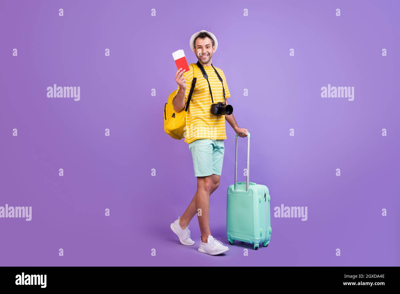 Full size profile side photo of young man happy positive smile travel abroad tickets bag isolated over violet color background Stock Photo