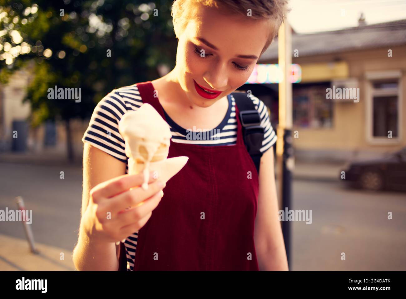 pretty woman with short hair eating ice cream on the street Stock Photo -  Alamy