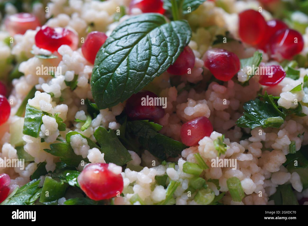Healthy salad with couscous, fresh mint, cucumber, pomegranate, lemon and olive oil. Eastern