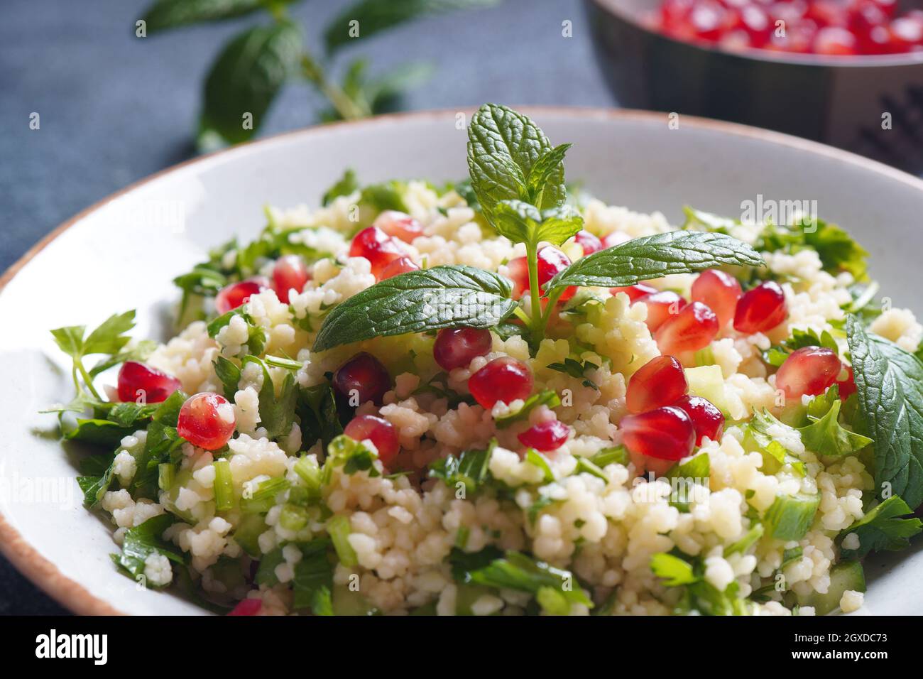 Healthy salad with couscous, fresh mint, cucumber, pomegranate, lemon and olive oil. Eastern