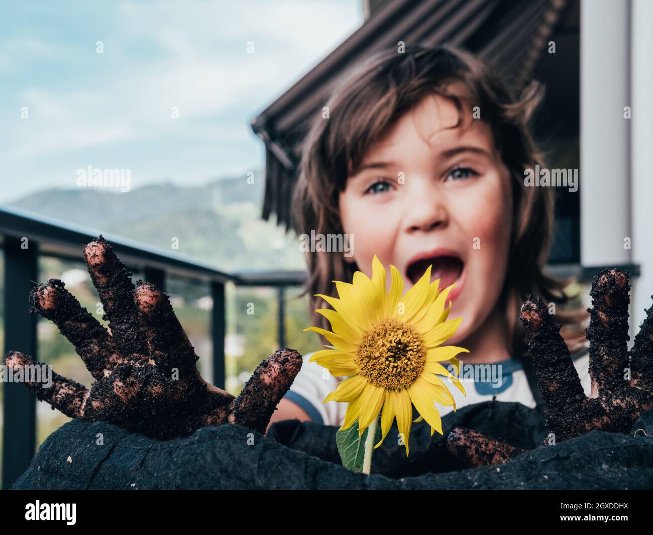 Carefree child with dirty hands and open mouth looking forward against