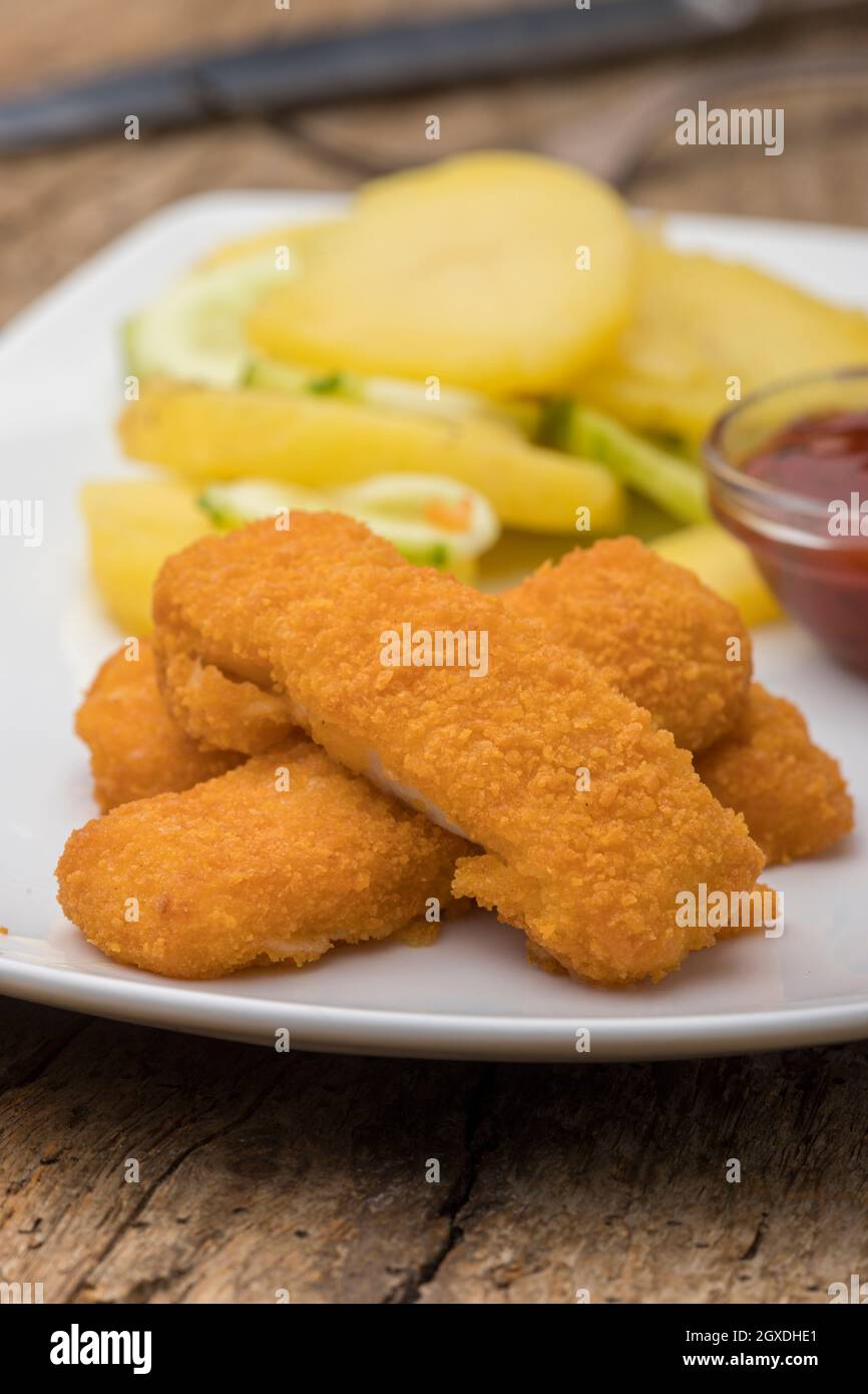 fish fingers with potato salad Stock Photo Alamy