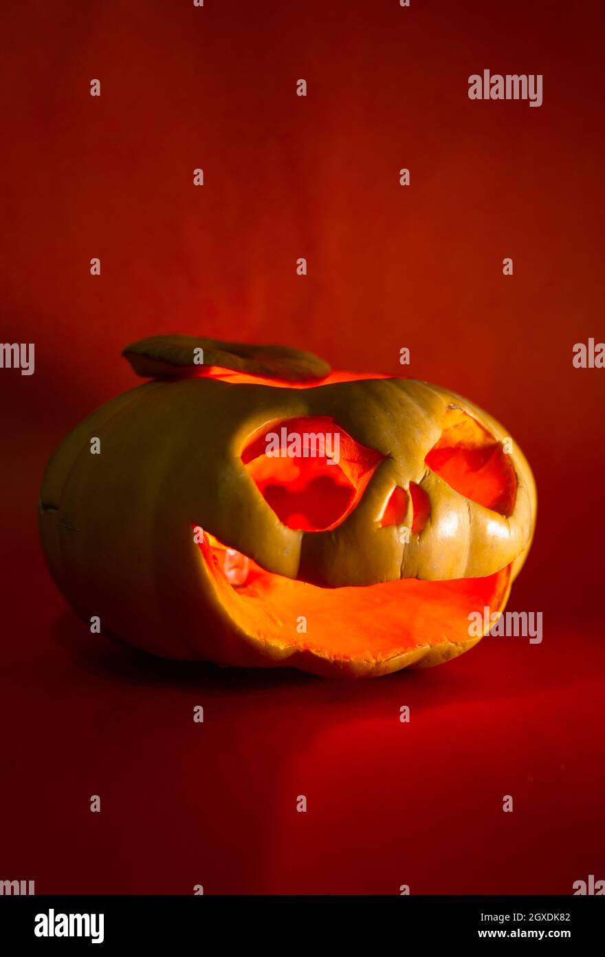 pumpkin with a carved face for Halloween on a red background Stock ...