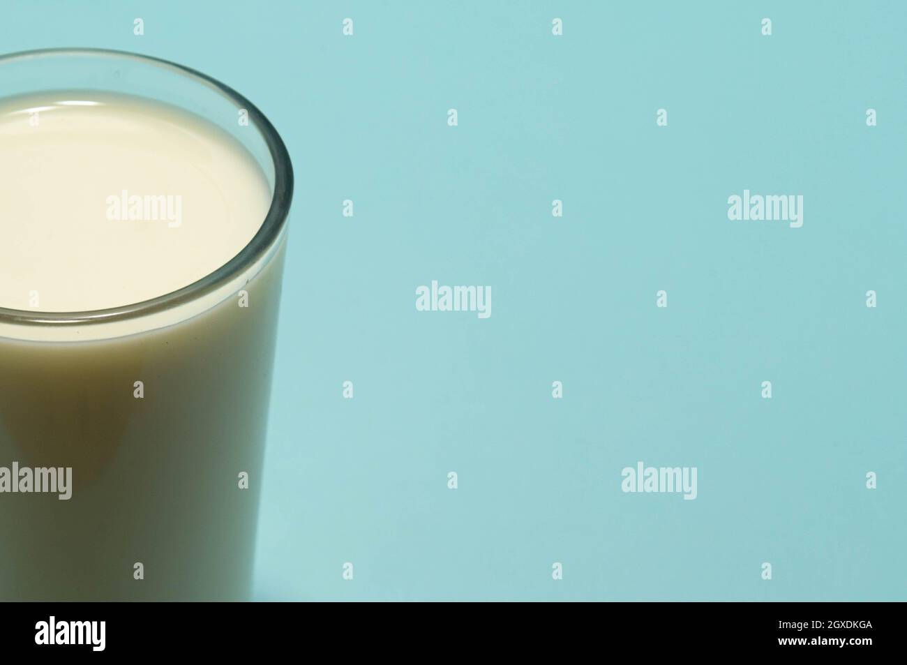 Glass cup served with milk on the blue background. Bone health food. Milk is one of the best sources of calcium available. Therefore, this food is ess Stock Photo