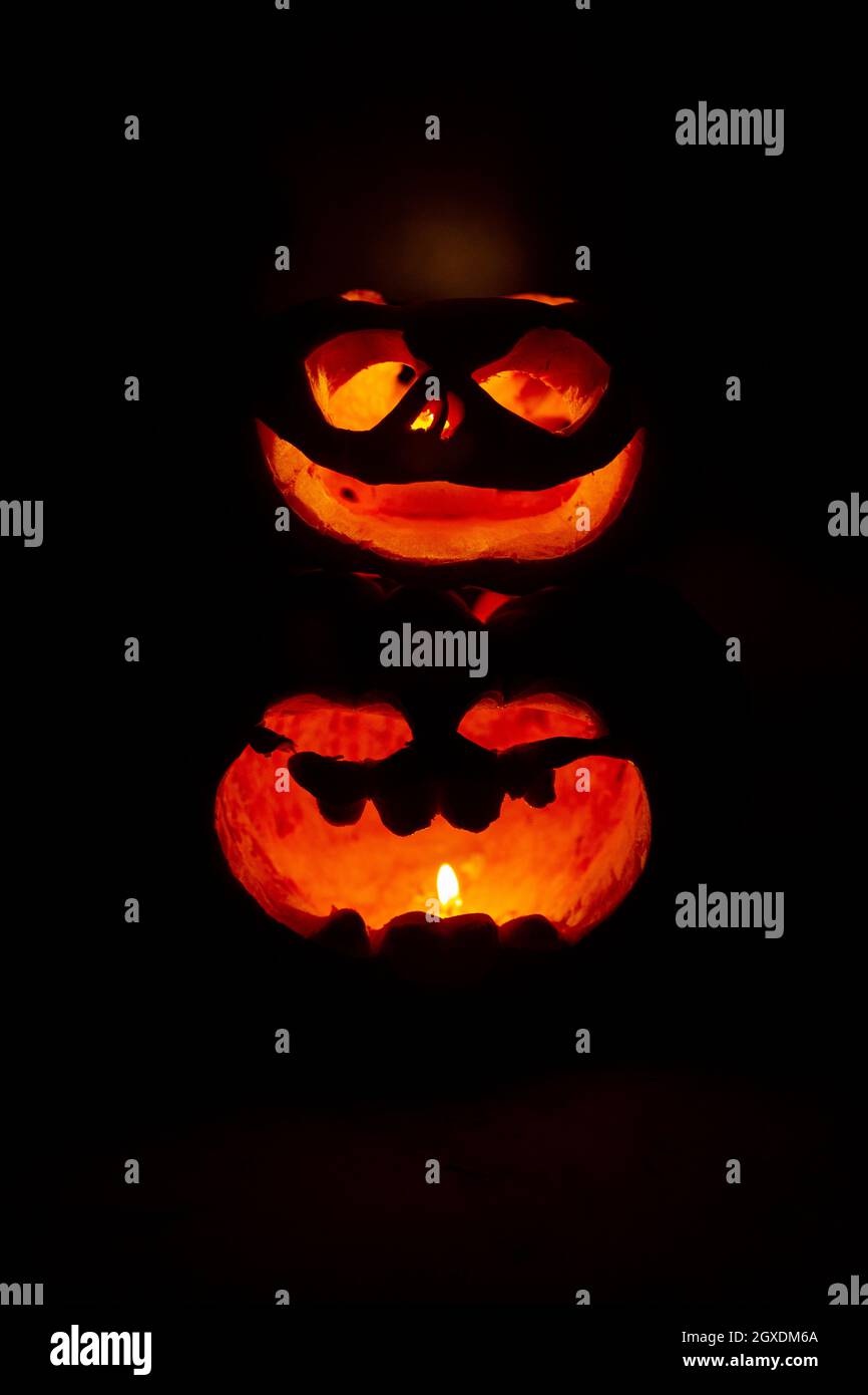 two glowing pumpkins with faces in the dark Stock Photo