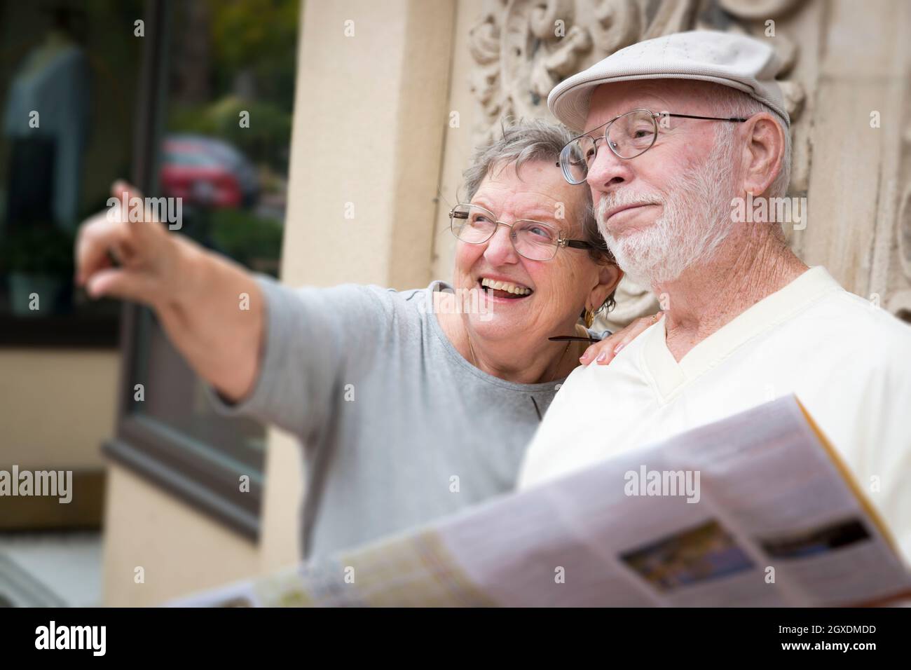 Happy Tourist Senior Couple Looking at Brochure Map. Stock Photo