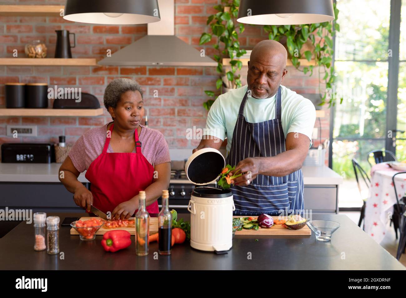 Serious african american senior couple cooking together in kitchen ...