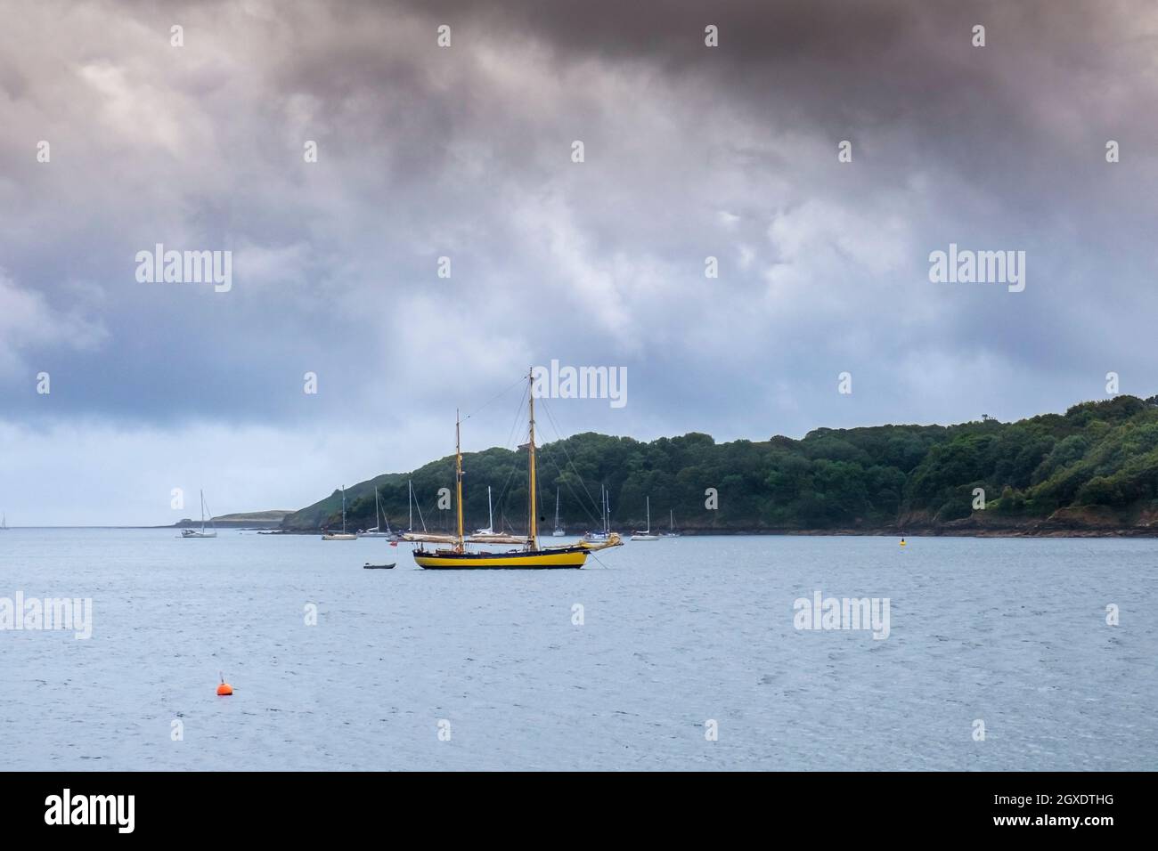 Gloomy cloudy weather over sailboats moored in the Helford River Passage in Cornwall. Stock Photo