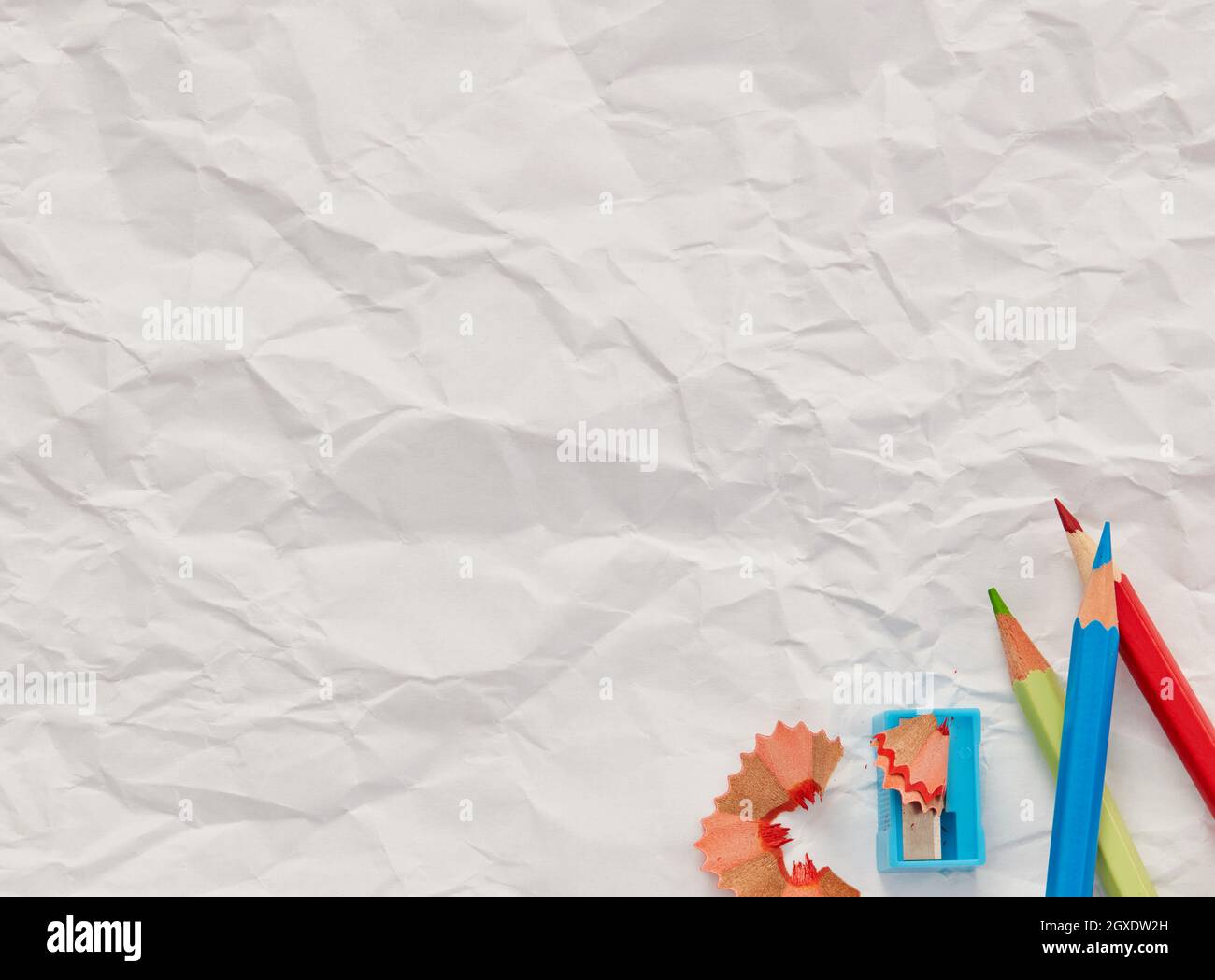 Pencils and sharpener on blank paper Stock Photo