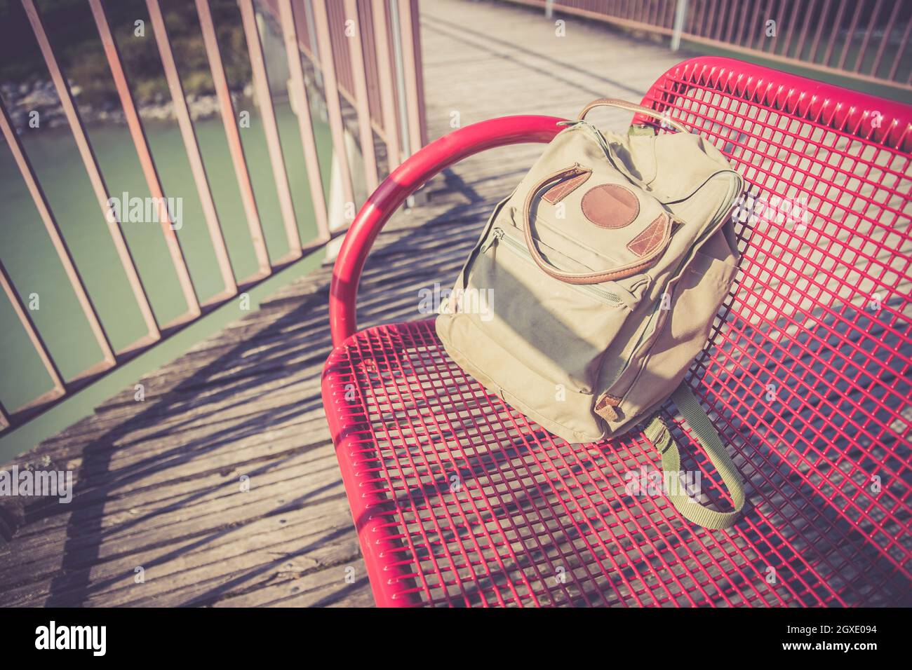 Vintage backpack is lying on red bench Stock Photo