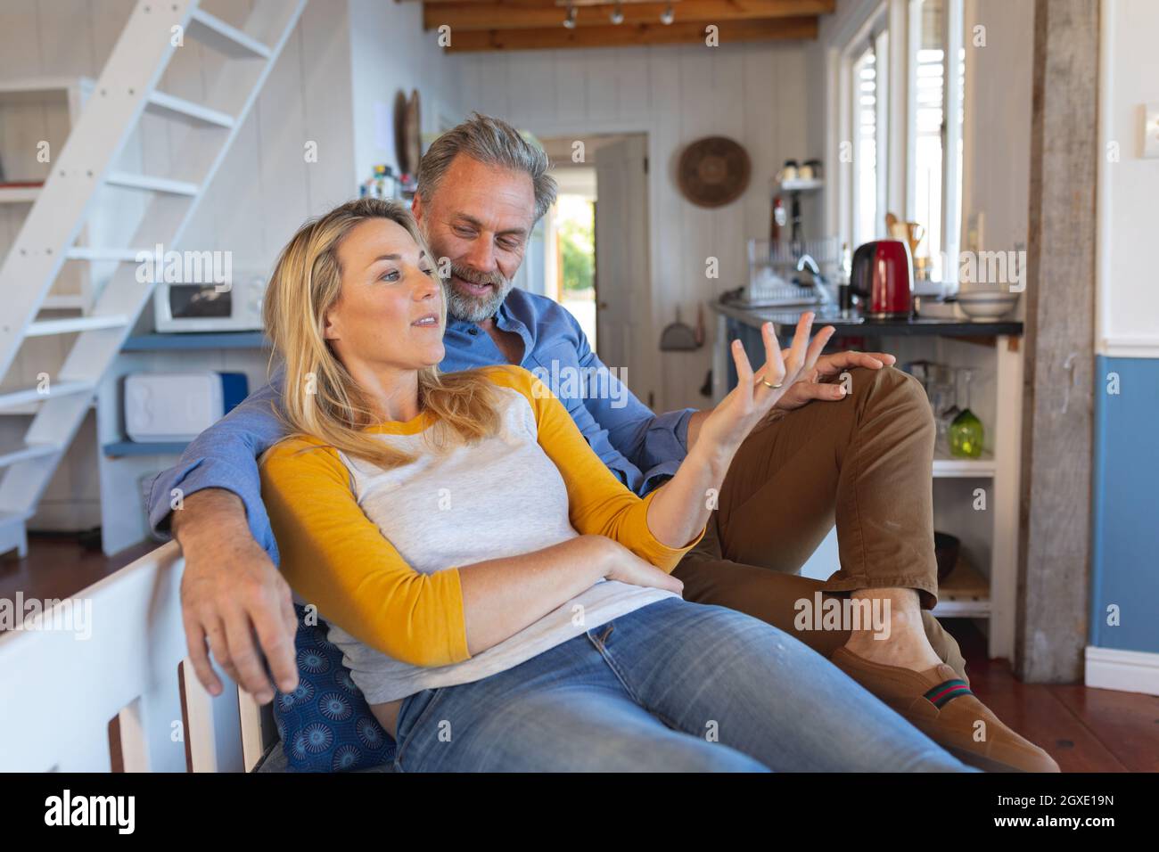 Happy caucasian mature couple sitting and talking in the kitchen Stock Photo