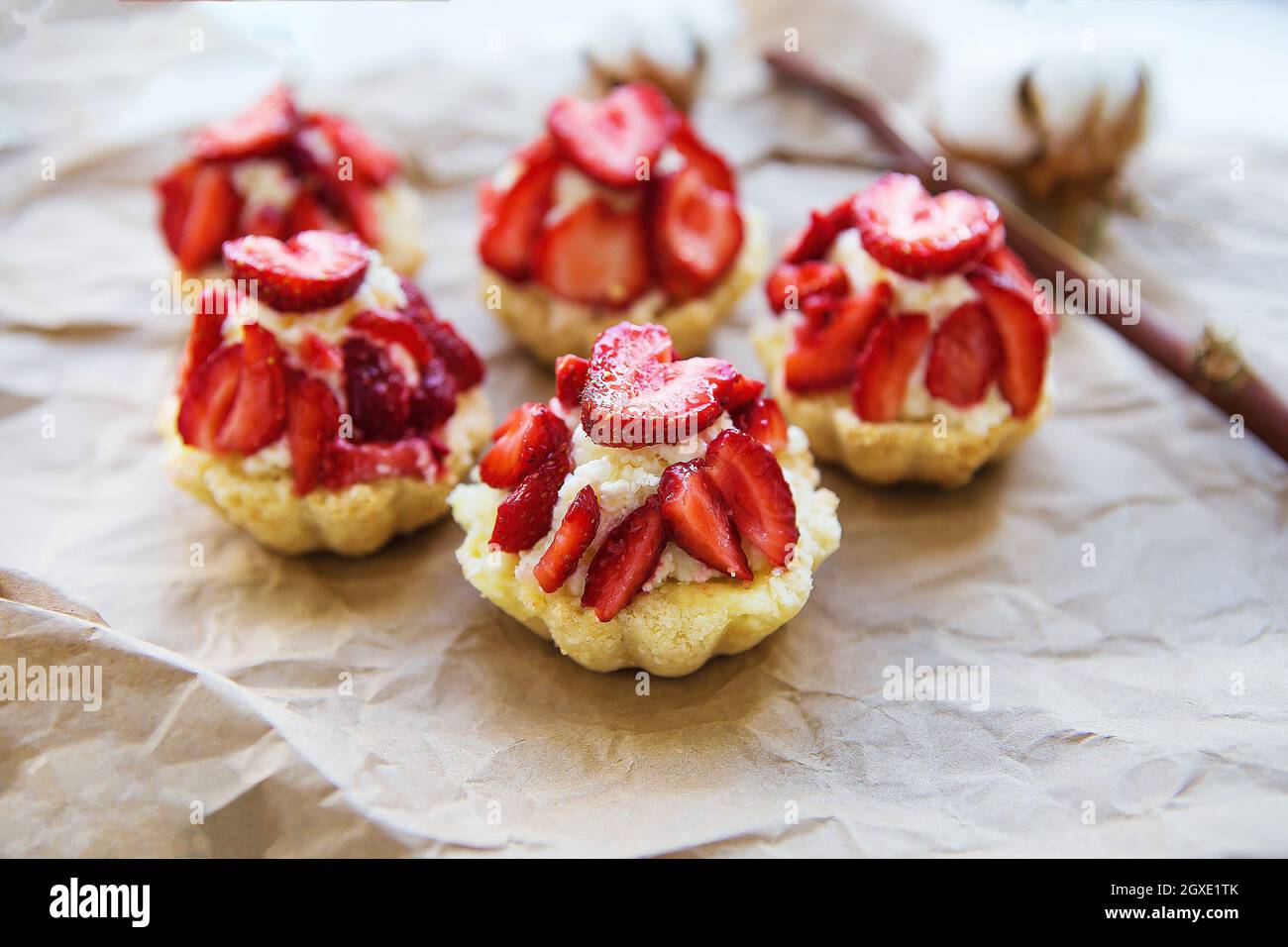 Very tasty muffins with fresh strawberries lie on kraft paper. Stock Photo