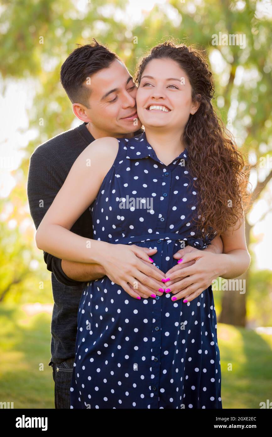 Happy Hispanic Man Hugs His Pregnant Wife Outdoors At The Park Stock ...