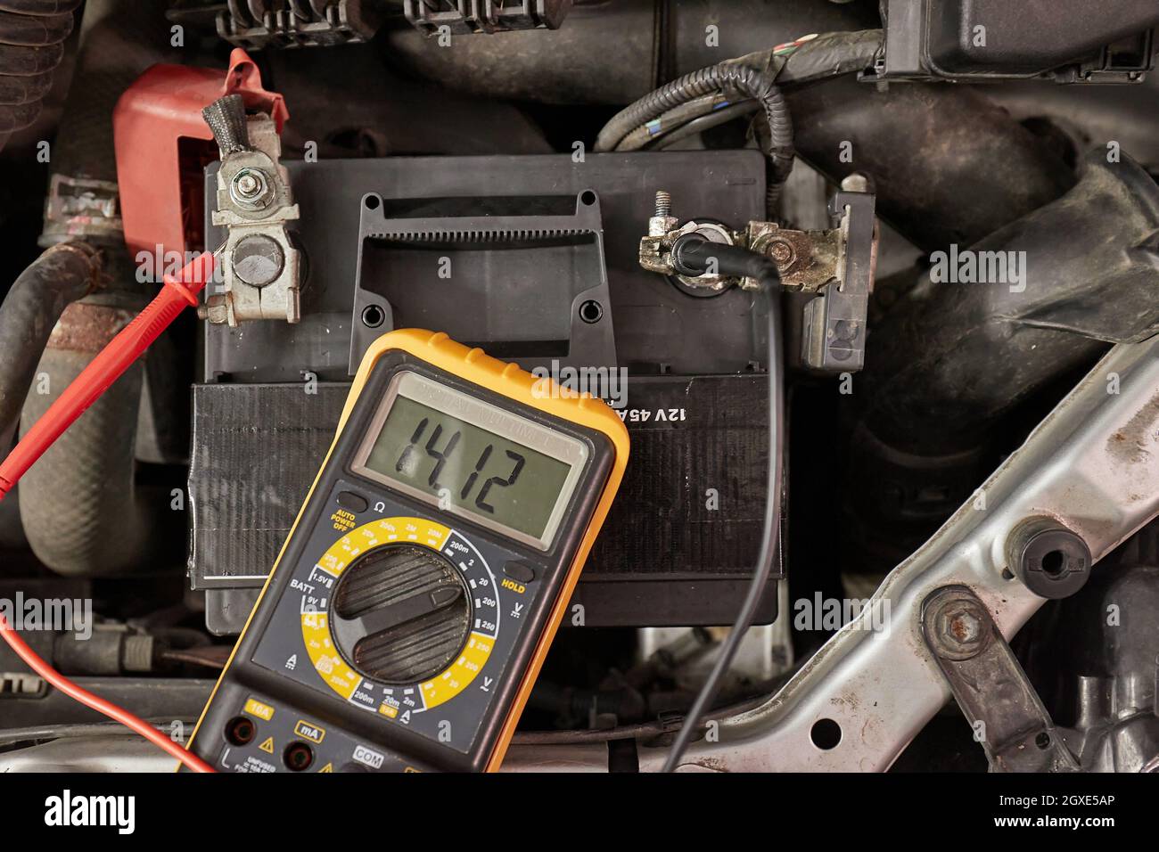 Car starter battery voltage measured with multimeter. Voltage above 14 volts as the alternator