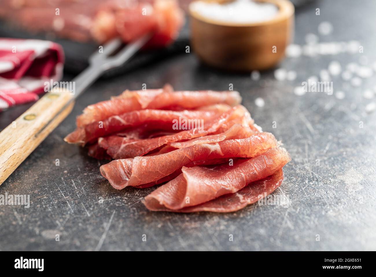 Sliced carpaccio. Raw beef meat on black table Stock Photo - Alamy