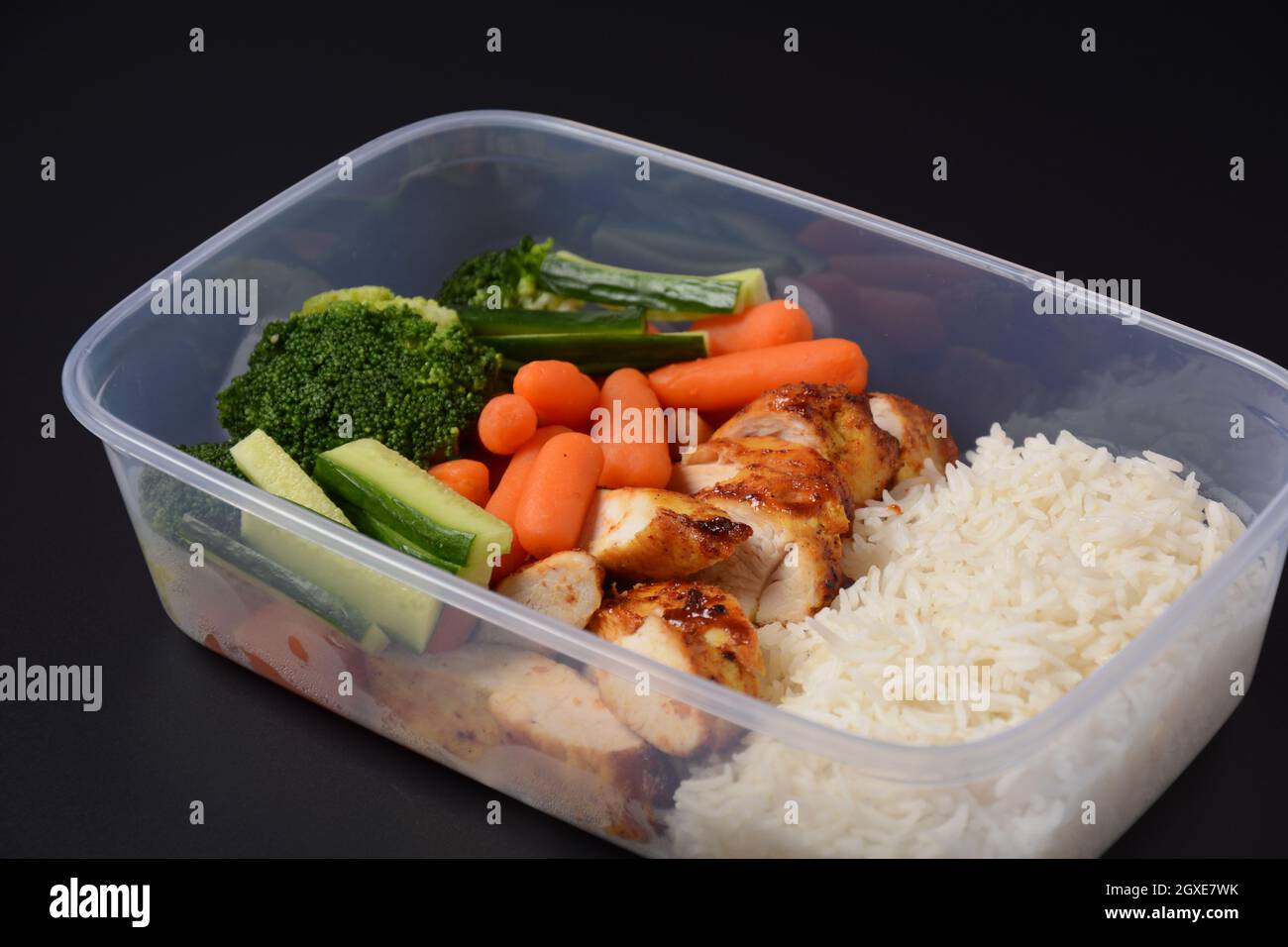 Healthy balanced lunch boxes. Grilled chicken, carrots, cucumbers ...