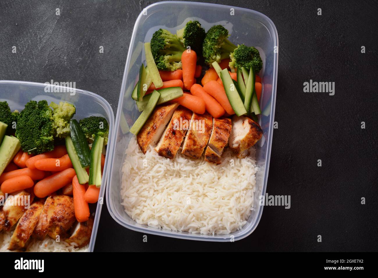 Healthy balanced lunch boxes. Grilled chicken, carrots, cucumbers ...