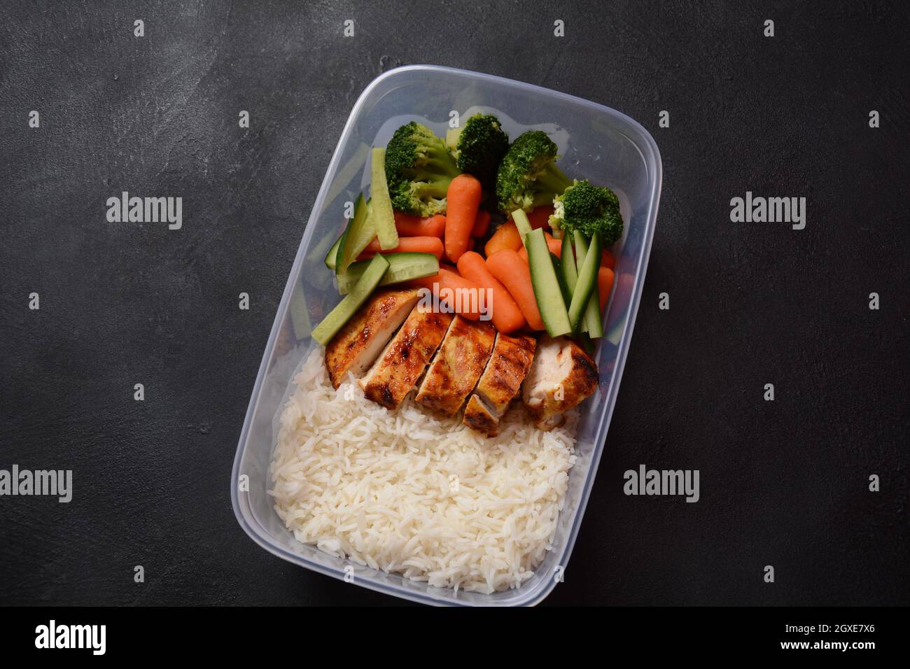 Healthy balanced lunch boxes. Grilled chicken, carrots, cucumbers ...