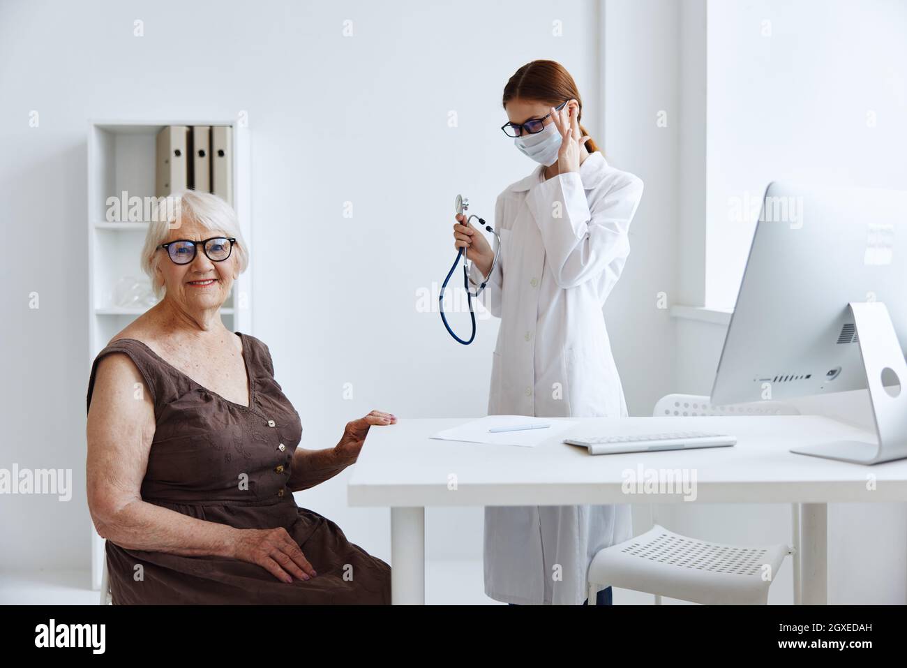 elderly woman patient on examination by a nurse stethoscope Stock Photo