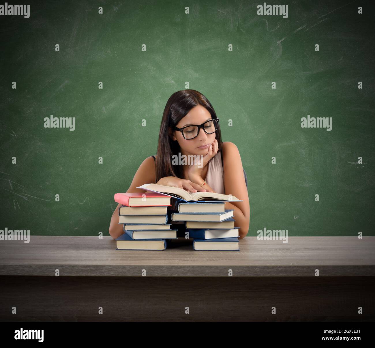 A young teacher concentrated reading a book Stock Photo - Alamy