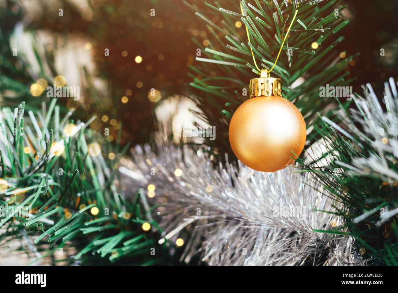 Golden ball on decorated Christmas tree with blurred lights bokeh ...