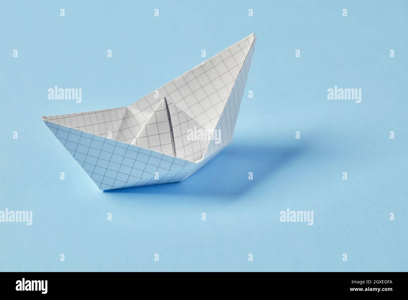 Paper boat on blue background Stock Photo