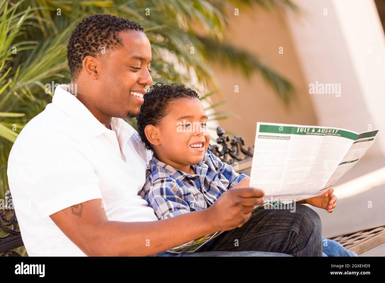 Happy African American Father and Mixed Race Son Having Fun Reading ...