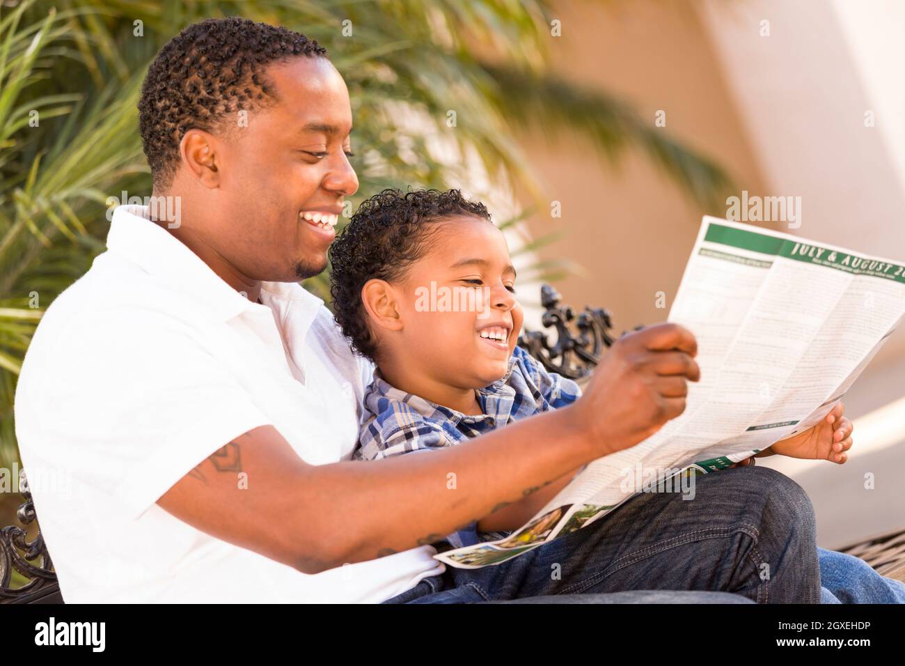 Happy African American Father and Mixed Race Son Having Fun Reading ...