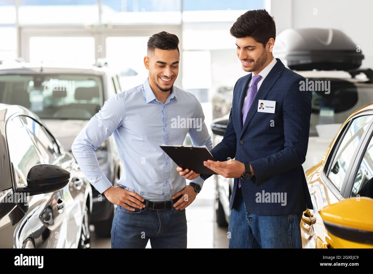 Attractive showroom manager showing customer car specifications Stock Photo Alamy