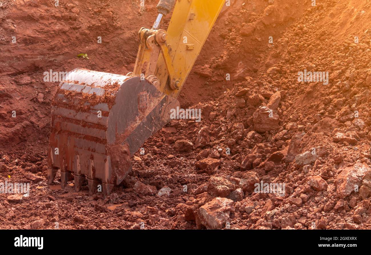 Backhoe working by digging soil at construction site. Bucket of backhoe