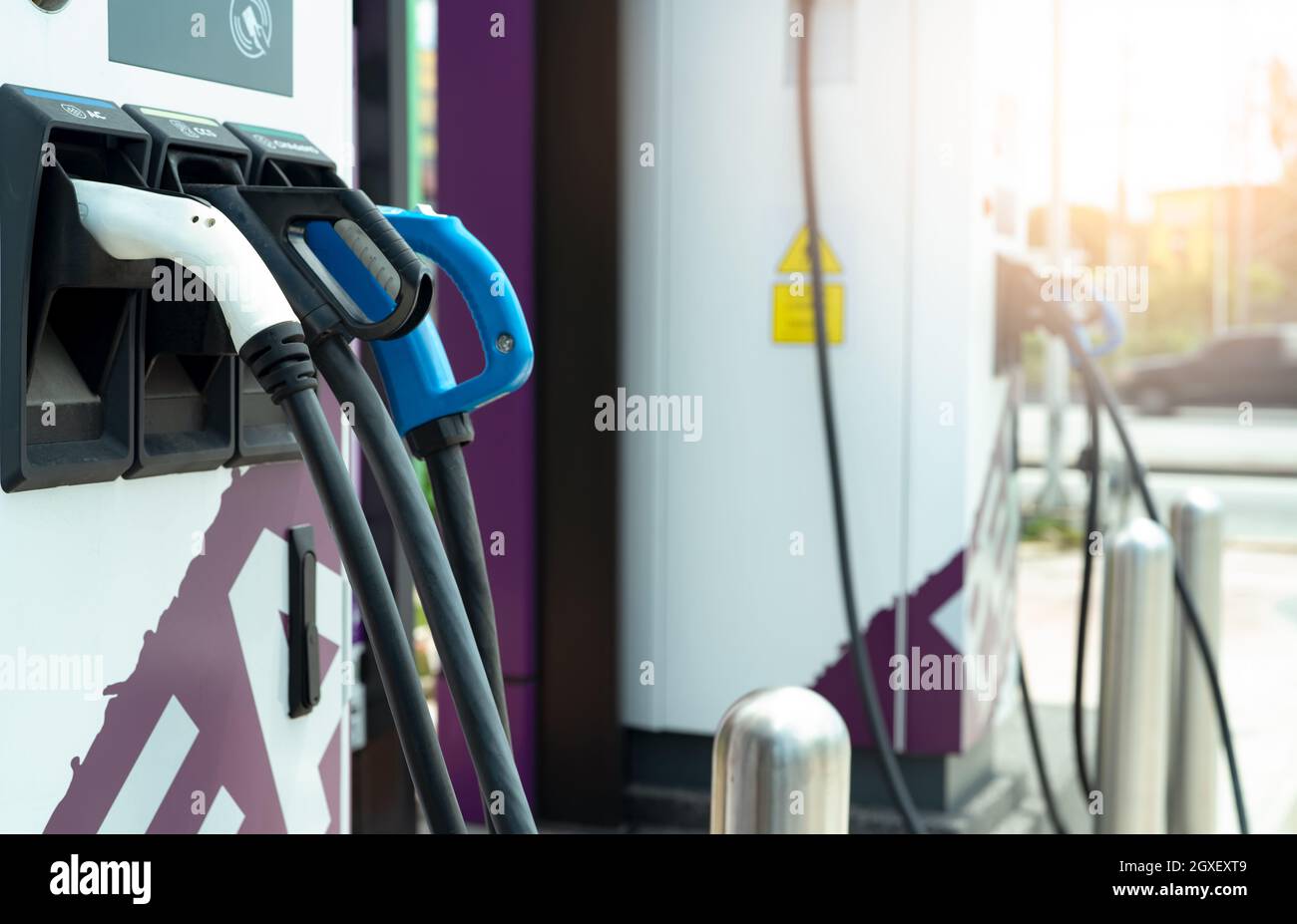 Electric car charging station for charge EV battery. Plug for vehicle with electric engine. EV charger. Clean energy. Charging point at car parking lo Stock Photo