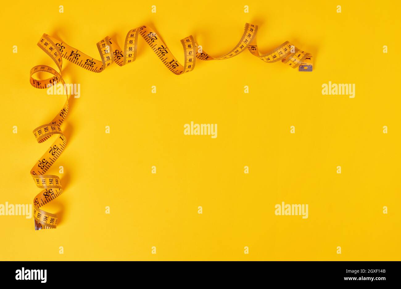 Tape measure on yellow background Stock Photo