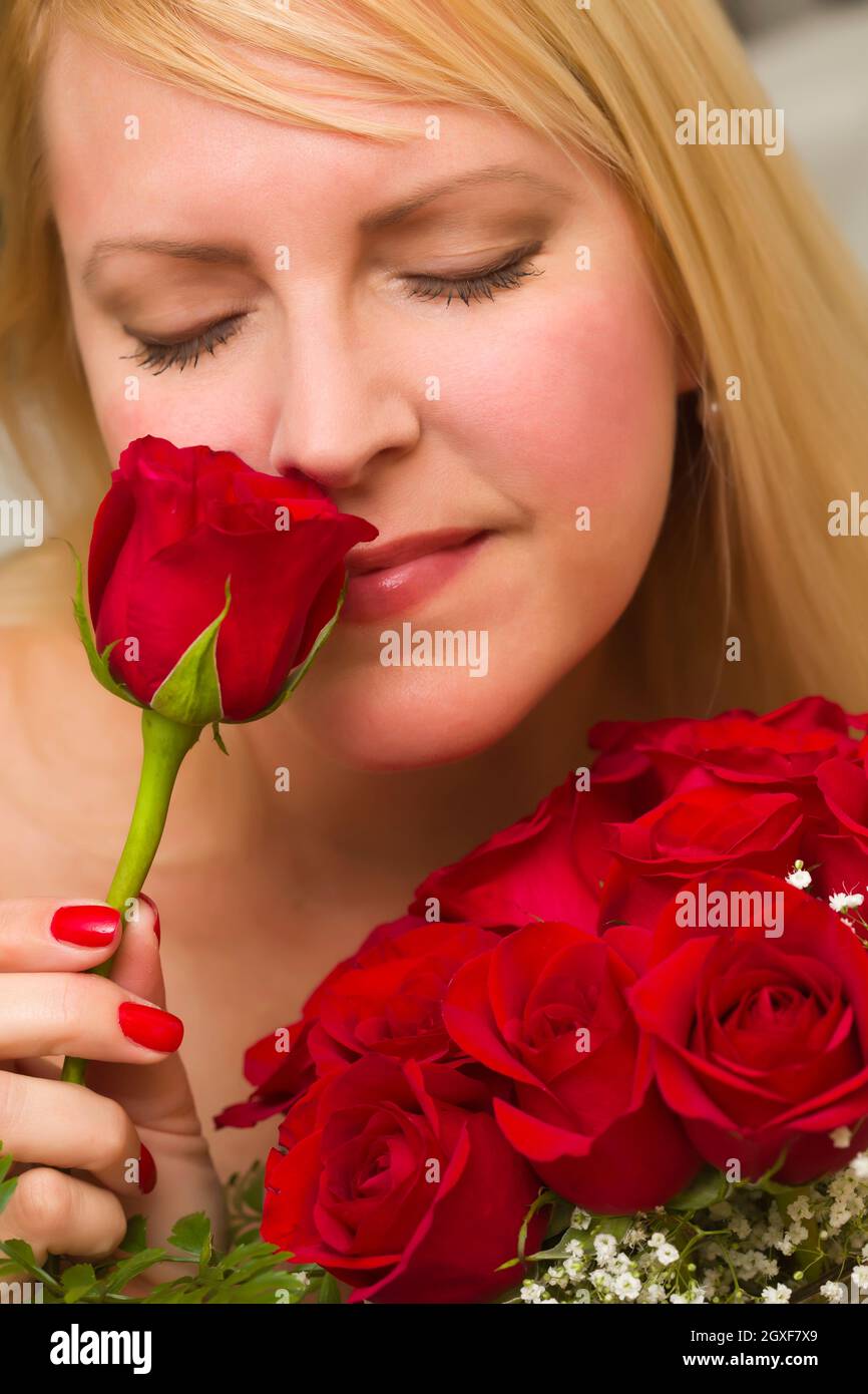 Beautiful Woman Smelling a Bunch of Red Roses Stock Photo - Alamy