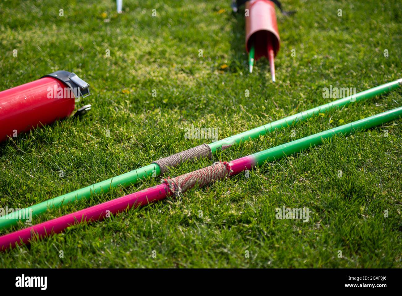 Track and field equipment outdoors in the green grass, two javelins