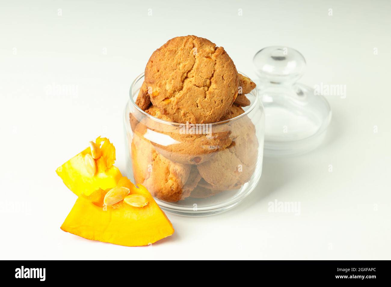 Jar with pumpkin cookies on white background. Stock Photo