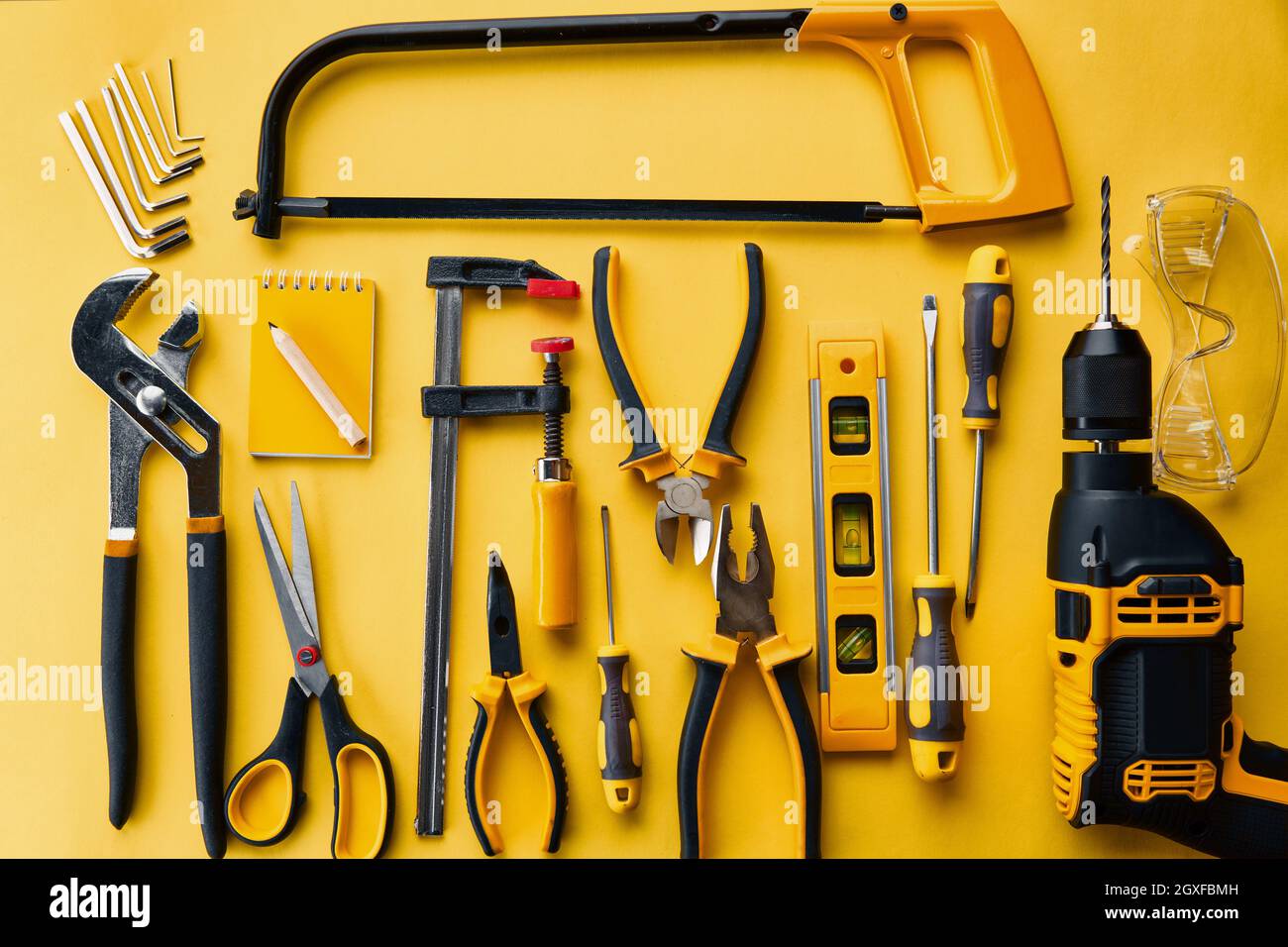 Professional workshop instrument, top view, yellow background, nobody.  Carpenter tools, builder equipment, screwdriver and piles, hacksaw and  level, s Stock Photo - Alamy