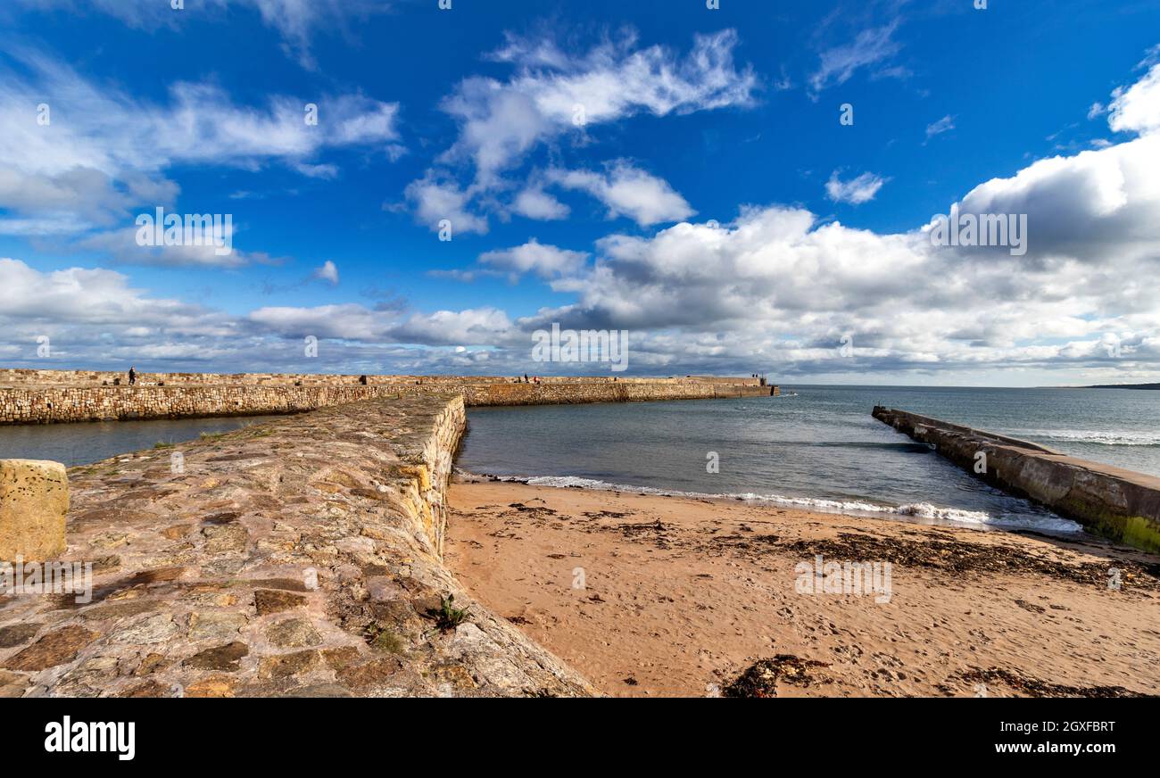 ST ANDREWS FIFE SCOTLAND THE HARBOUR WALLS A SANDY BEACH THE BAY AND A BLUE SKY Stock Photo