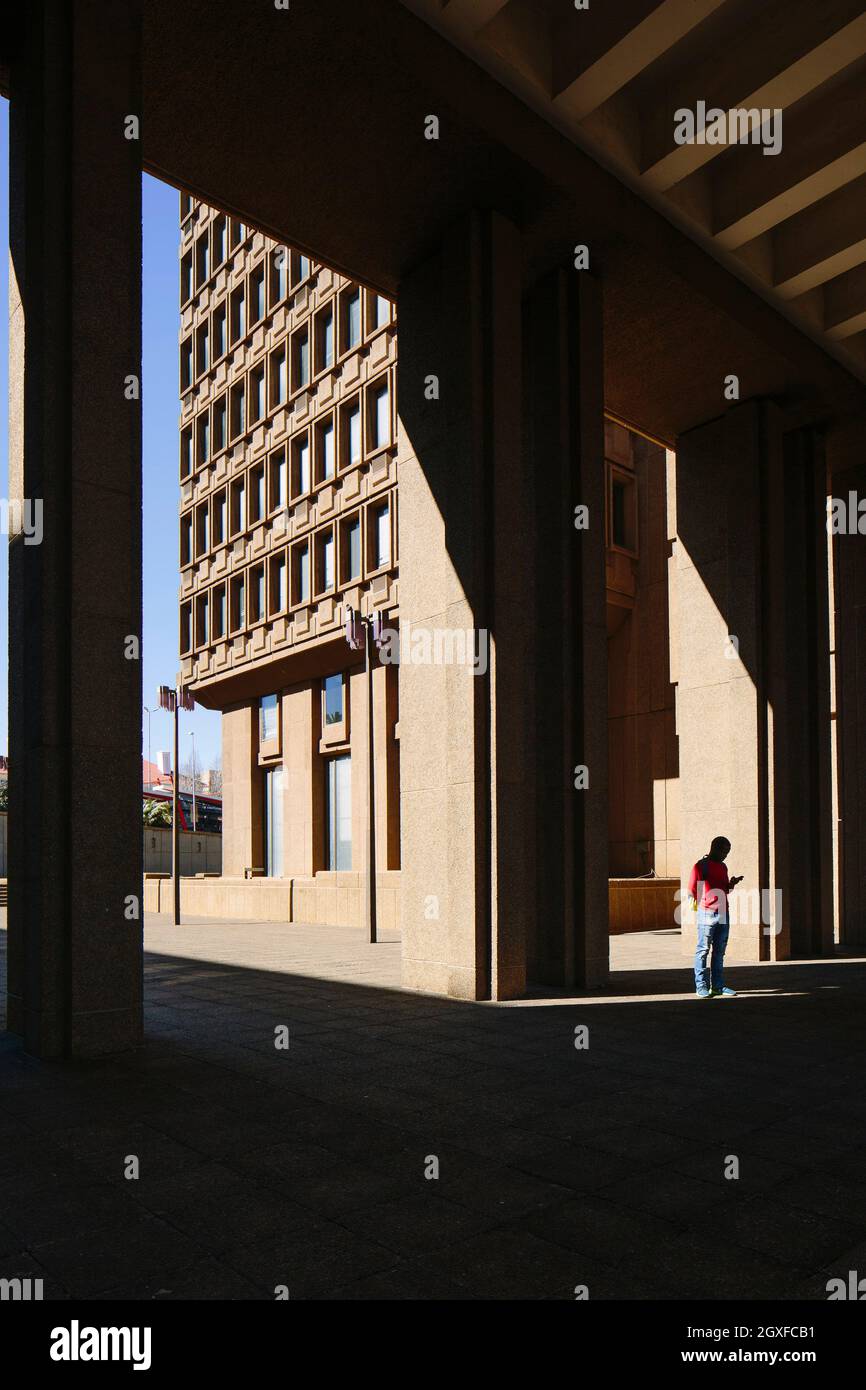 Inside a covered walkway between buildings, with the harsh light